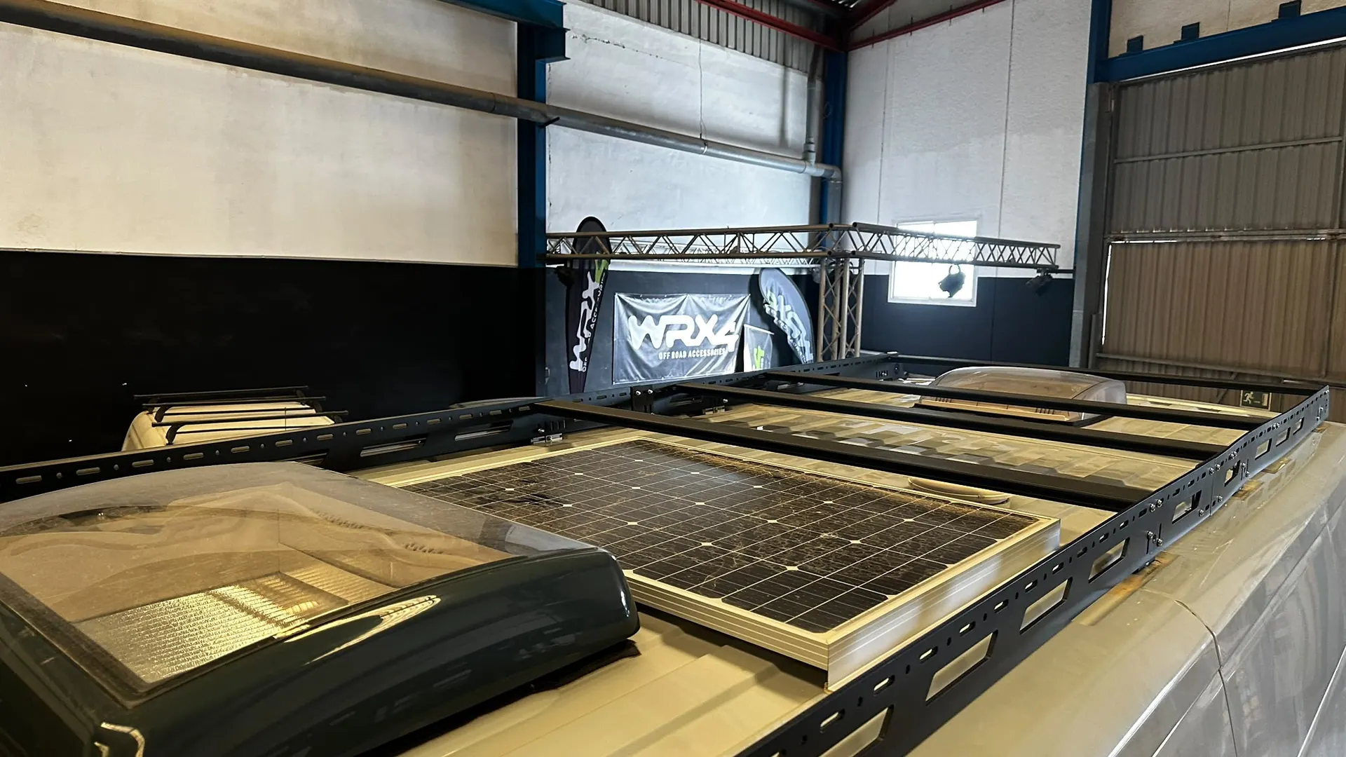 Rack WRX4 con una placa solar y una claraboya debajo, sobre el techo de una autocaravana