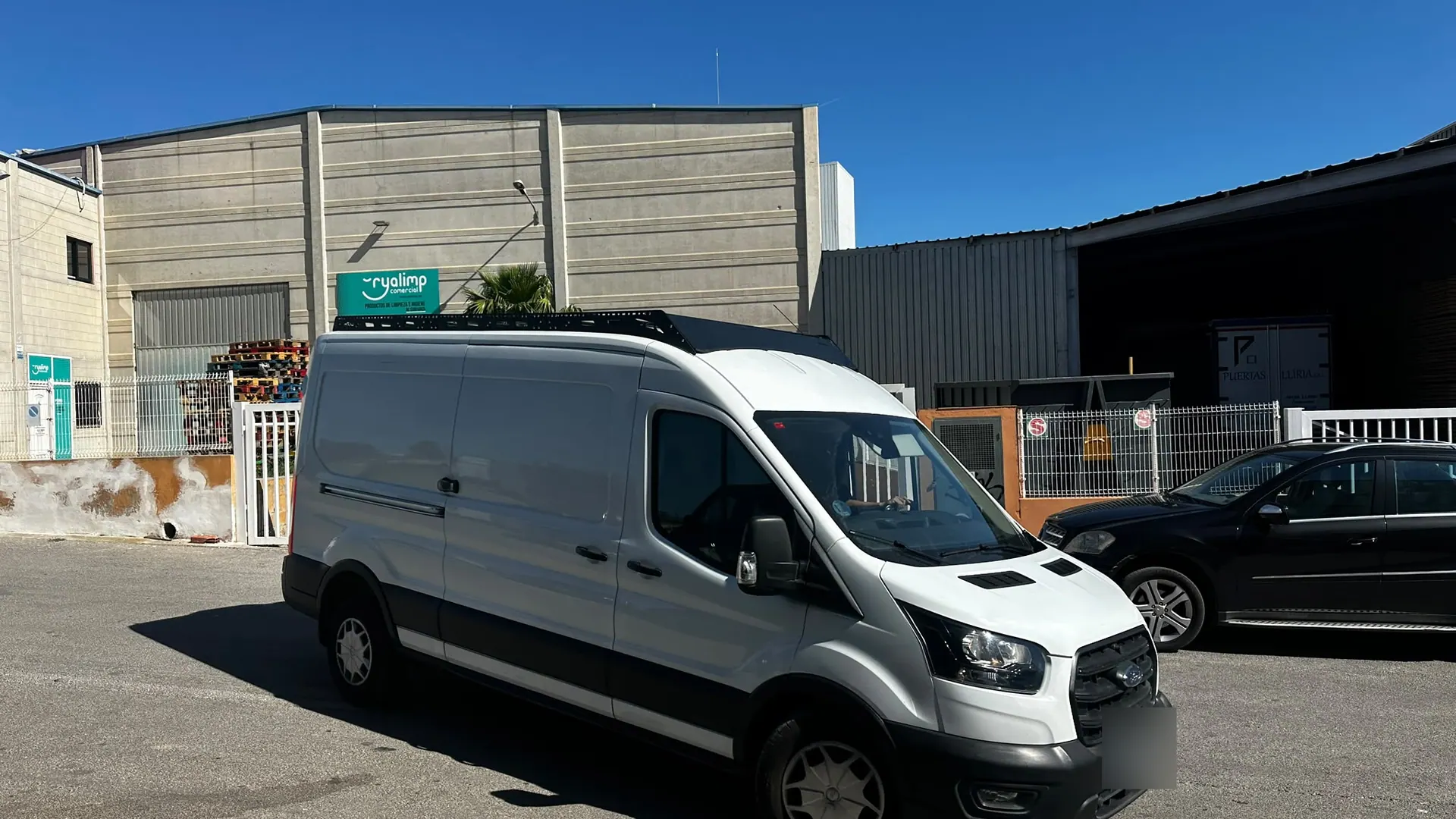 Ford Transit blanca con el rack WRX4, vista delantera de tres cuartos